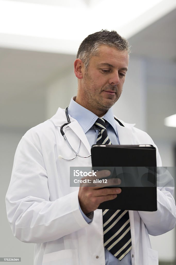 Doctor Using Touchpad Portrait of a male doctor. Beautiful People Stock Photo