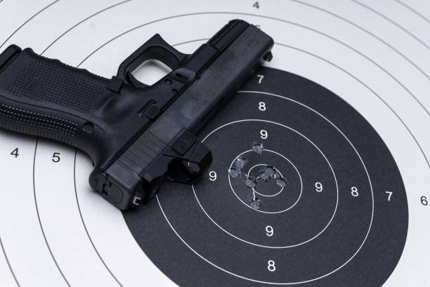 istock Pistol on the paper target with holes from bullets 1752268059