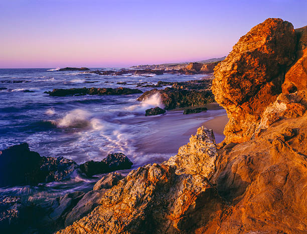 The rocky shoreline of Pescadero State Beach in California glows with the late light of the day.