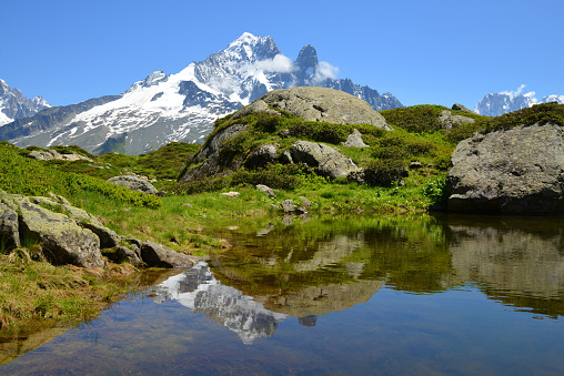 Mountain landscape reflected on the surface of the lake. Nature Reserve Aiguilles Rouges, French Alps, France, Europe.
