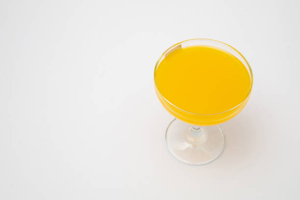 Orange juice in wine glass on white background