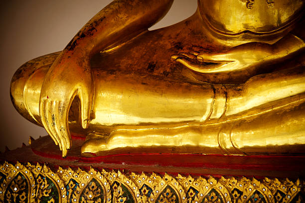 A close-up side profile of a beautifully crafted Thai Apsara statue, adorned with an elaborate headdress and intricate jewelry. The delicate facial features and refined details highlight the artistry and cultural significance of this celestial figure, representing divine femininity and grace in Southeast Asian mythology. The warm, moody lighting enhances the statue's mystical presence, while the softly blurred background adds depth, making this image a perfect representation of Thai heritage, spiritual devotion, and traditional craftsmanship.