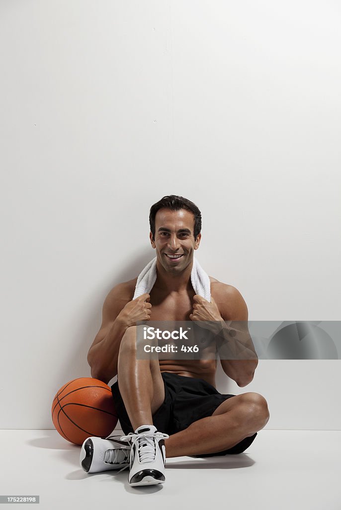 Jogador de basquete leaning agaisnt uma parede - Foto de stock de Basquete royalty-free