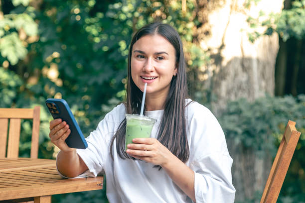 istock A woman drinking matcha latte coffee and using smartphone in a cafe 1752282068