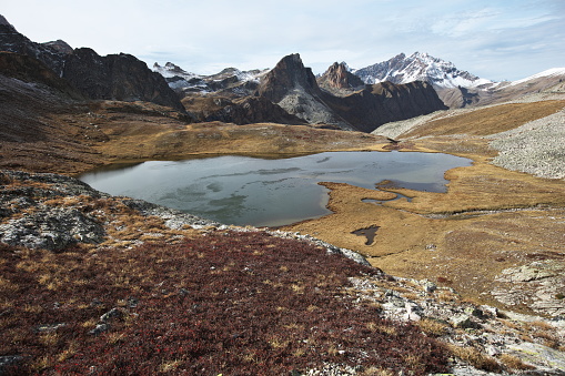 Photo taken towards the northwest towards the Aiguille Large 2857m (in the center of the image) with the Aiguille Pierre-André 2812m to its right and the Font de Sancte peaks dusted with snow.\nThis lower Roure lake gives rise to the Beal du Roure, a tributary of the Mary torrent which confluences with the Ubaye to the right of the hamlet of Maljasset