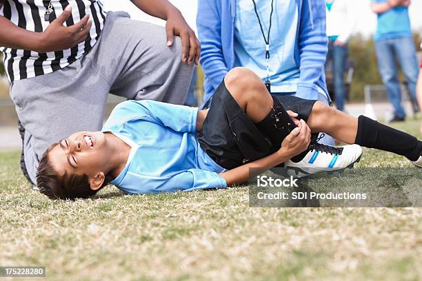 Giovane Ragazzo Tenendo Una Lesione Alla Caviglia Durante La Partita Di Calcio - Fotografie stock e altre immagini di Lesionato