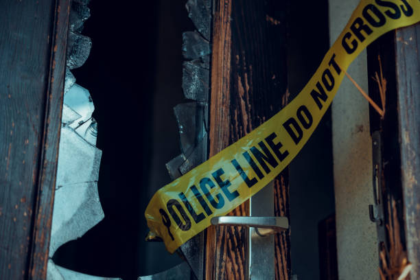 Yellow police cordon tape on broken door