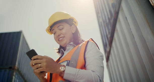 istock Woman, engineer and smartphone for communication, container project and shipping. Logistics, cargo and smile for email, technology and texting for networking, contractor or freight distribution 1752283924