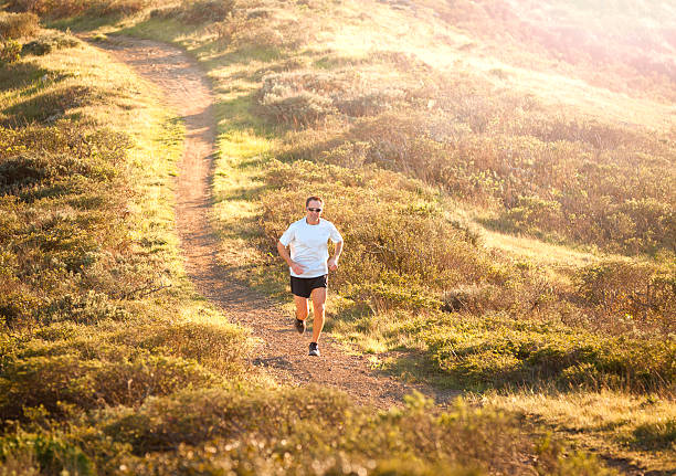 A man running a trail in the Marin Headlands in the late afternoon.