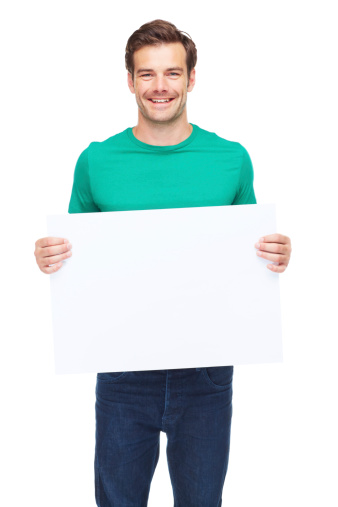 A studio shot of a young man holding up a blank sign isolated on white
