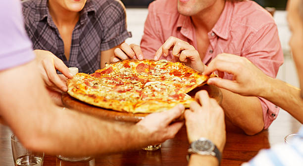 istock group of friends sharing a pizza 175229319