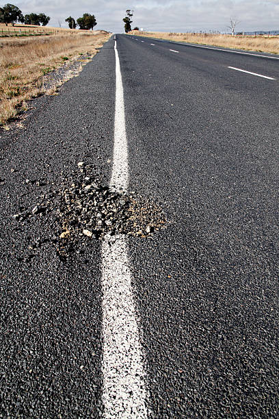 Australian pothole in bitumen country road stock photo