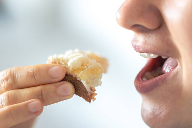 A woman eats bread with grated cheese, close-up.
