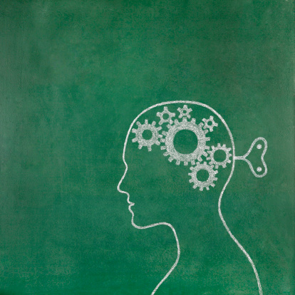 Human head with set of gears on his mind drawn on blackboard