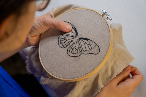 istock Woman embroidering a butterfly by hand 1752304733