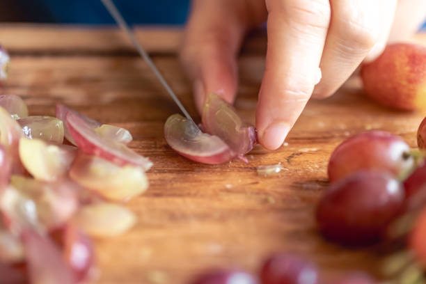 istock A woman cuts grapes on a cutting board. 1752308309