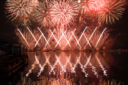 A colorful fire works during a celebration in the river with beautiful reflection in the water
