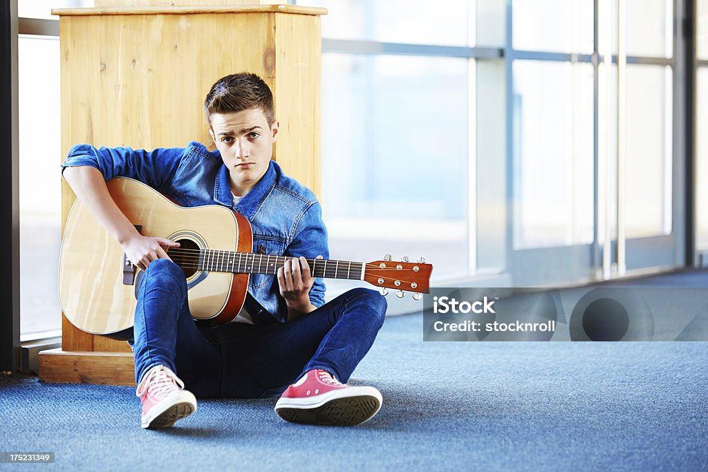 Adolescente décontractée avec guitare assis sur des tapis dans les couloirs - Photo de Activité libre de droits