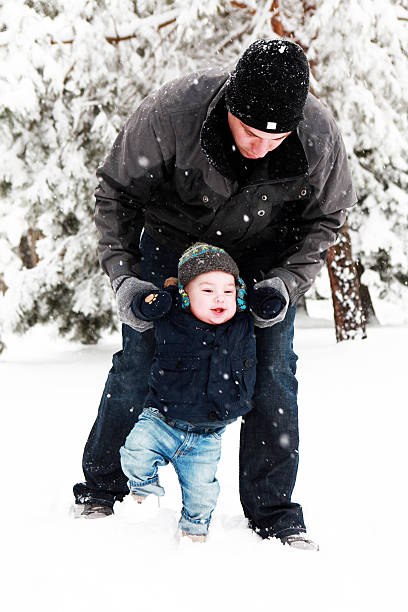 istock Baby Boy Walking Through Snow With His Dad 175231458