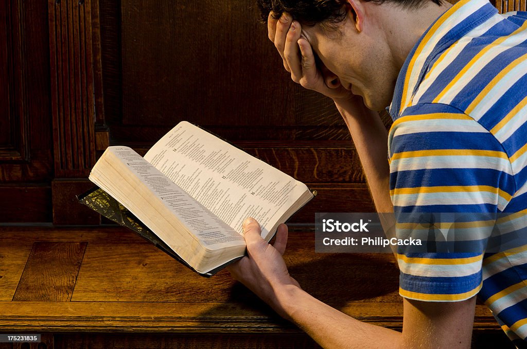 Młody człowiek Praying i czyta biblię - Zbiór zdjęć royalty-free (Antyczny)