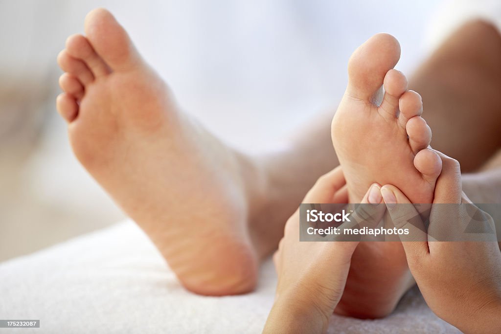 Reflexology foot massage Close-up of hands of massage therapist giving a foot massage Reflexology Stock Photo