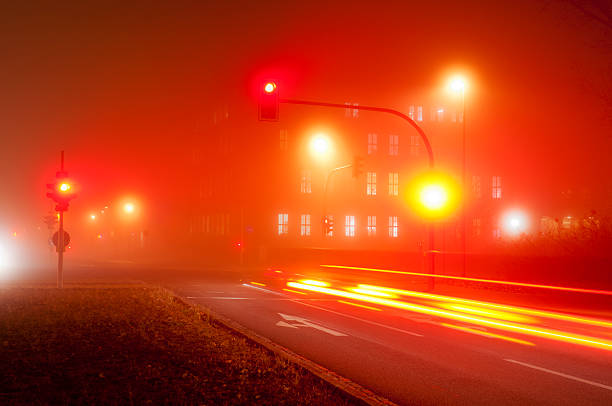 信号のある交差点に霧 - lichtspur ストックフォトと画像