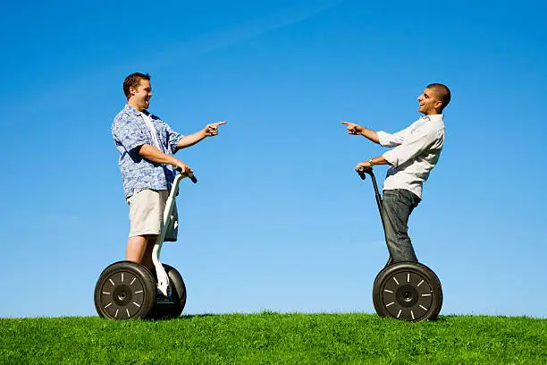 Photo of two friends having fun on their personal transport devices.