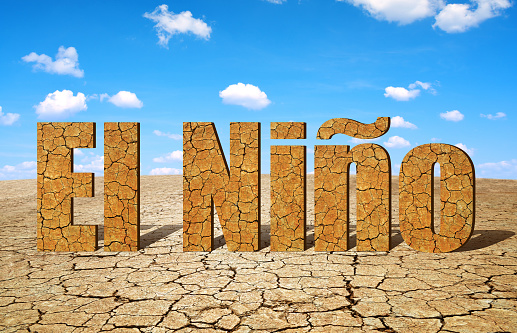 Landscape with dry cracked soil and El Nino text. Concept of change climate.