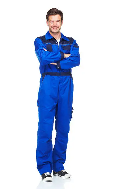 A full length studio shot of a smiling young mechanic in overalls isolated on white