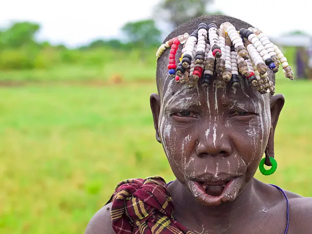 "Traditional Mursi tribe woman, piercing her lips and ears  for inserting disks made of clay. It is south Ethiopia near Kenya, East Africa as part of Mago National Park."