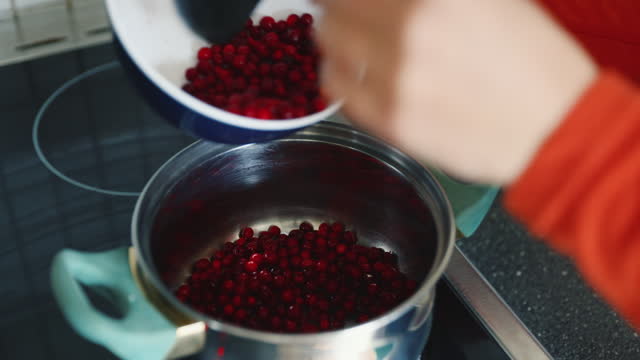 Woman Preparing Lingonberry Jam in Kitchen
