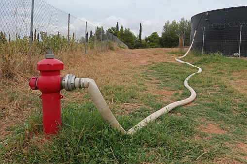 Fire hydrant with hose connected to water tank.
