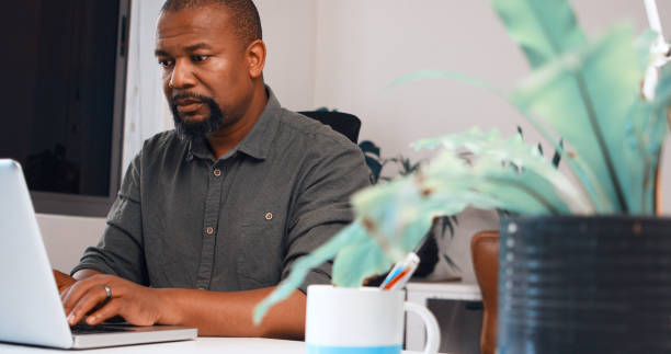 istock Black man, laptop and typing in office for thinking, planning to problem solving with budget, report or analysis. African entrepreneur, computer and click for finance stats, data analytics or reading 1752355535