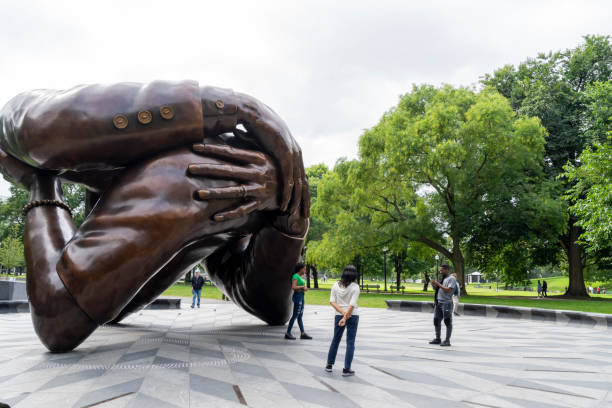 The embrace sculpture with tourist around it. The Embrace is a bronze sculpture by Hank Willis Thomas on Boston Common. The artwork commemorates Martin Luther King Jr. and Coretta Scott King, it is if the hug they shared after he was awarded the Nobel Peace Prize in 1964. Boston, Massachusetts, USA civil rights act stock pictures, royalty-free photos & images