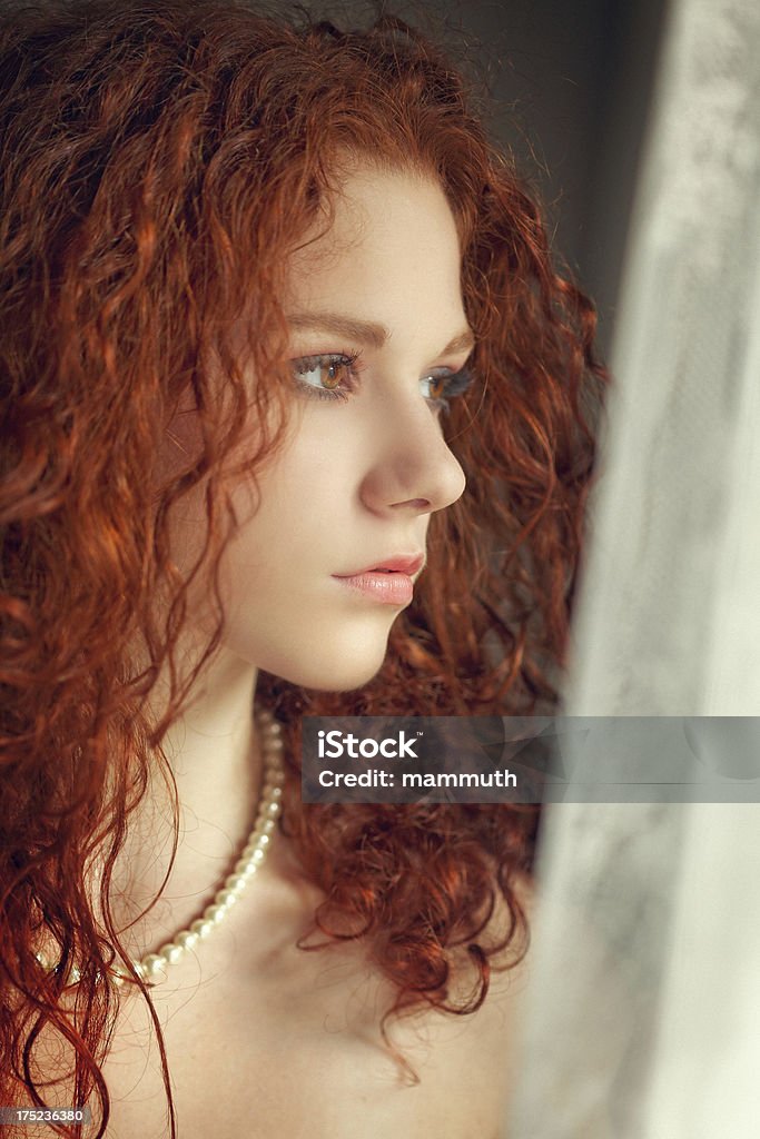 Attraente donna guardando fuori dalla finestra - Foto stock royalty-free di 16-17 anni