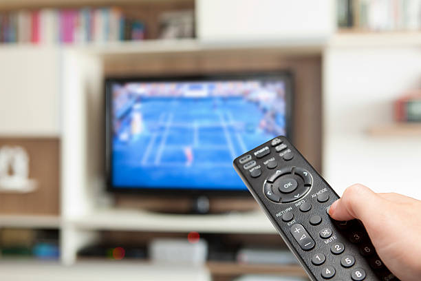 istock watching tennis with TV remote control in hand 175236788