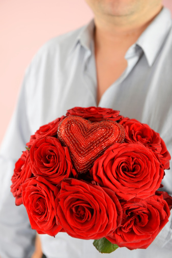 man holding a bouquet of red roses close-up