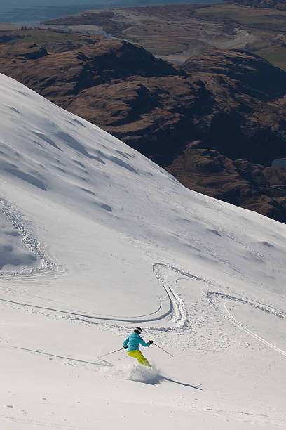 young women skiing powder snow, New Zealand stock photo