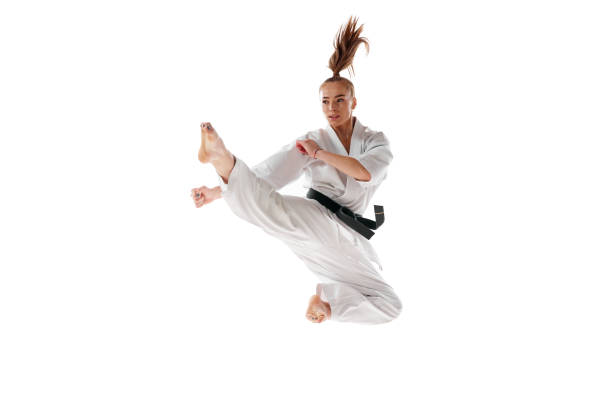 istock Young woman in white uniform workout, train martial arts in action isolated over white studio background. 1752373014