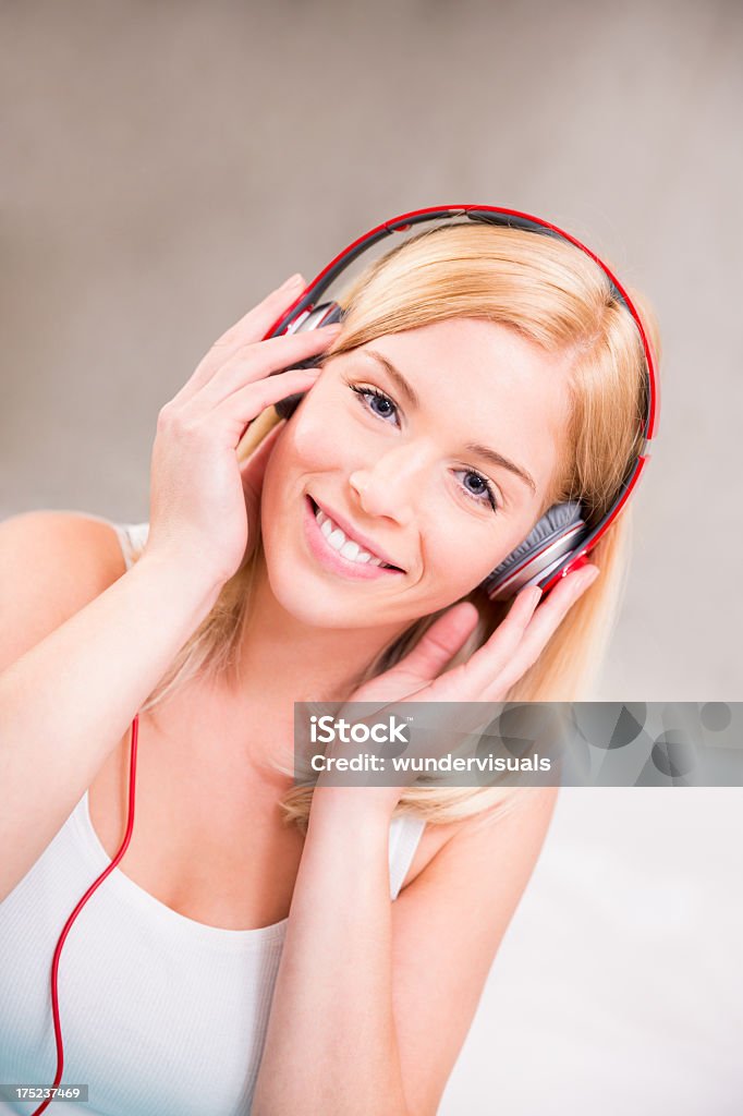 Ragazza a letto con le cuffie ascoltando musica - Foto stock royalty-free di 20-24 anni