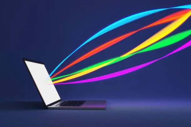 Colorful rainbow colors of light streaks coming out of a laptop screen on deep blue background. Illustration as design element for computer and technological topics