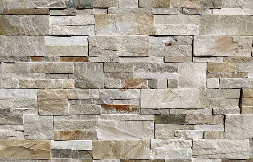 Muro de piedra formado por rocas grises, marrones y blancas de diferentes tamaños y formas. photo