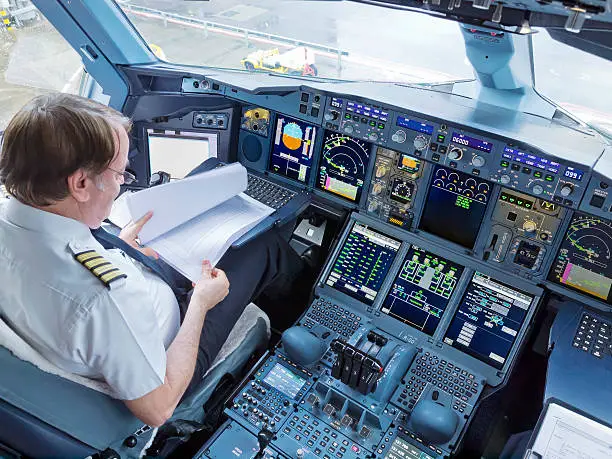 A Captain completing pre-flight preparations in the flight deck of an Airbus A380-800.