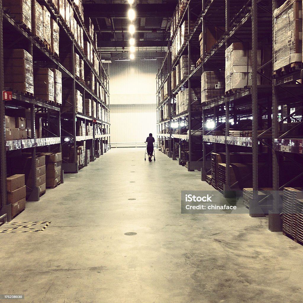 lonely man walking at warehouse interior of dard warehouse, Mobilestock photo: Photographed with iPhone 4s........... Adult Stock Photo