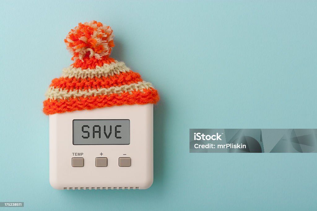 SAVE on digital room thermostat with wooly hat The word SAVE on a digital room thermostat wearing wooly hat. Heat - Temperature Stock Photo