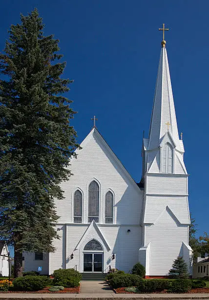 "Beautiful white Catholic Church in Lancaster, New Hampshire, USA with tall steeple."