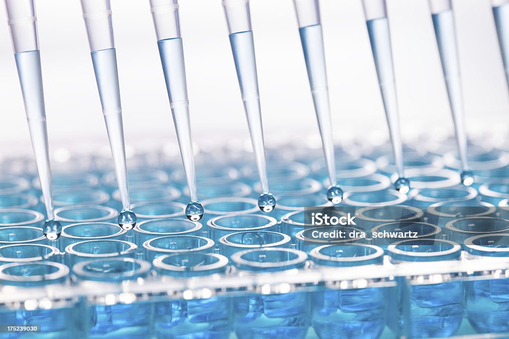 Blue liquid dripping from funnel into test tubes Test tubes PCR Device Stock Photo