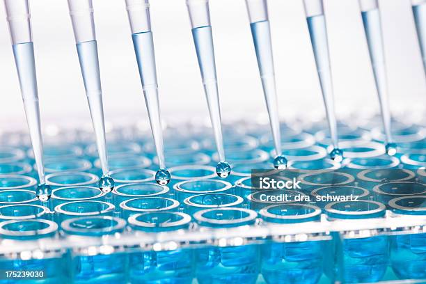 Blue Liquid Dripping From Funnel Into Test Tubes Stock Photo - Download Image Now - PCR Device, Laboratory, Pipette