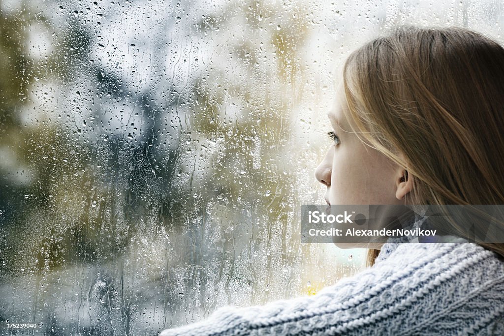 Serie: Niña mirando a través de la ventana en un día de lluvia - Foto de stock de Tristeza libre de derechos