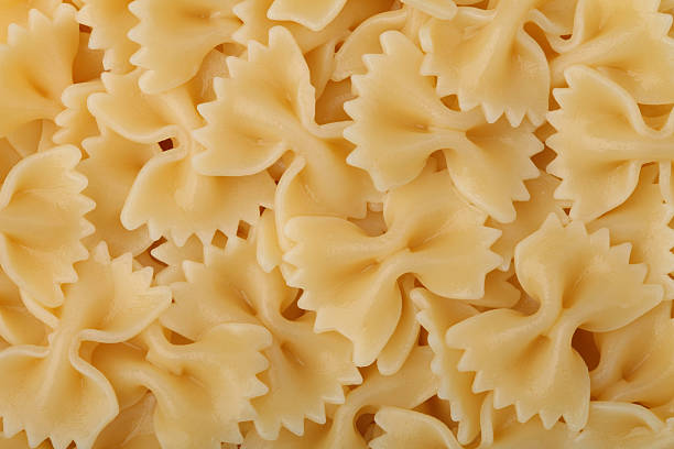 gotowane makaron kokardki tle - bow tie pasta italian cuisine bow heap zdjęcia i obrazy z banku zdjęć